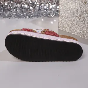 Detail view of anti-slip rubber sole on platform rhinestone slides with cork footbed.