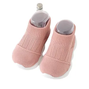 Comfortable soft pink knitted baby sock shoes with white soles for toddlers' first steps.