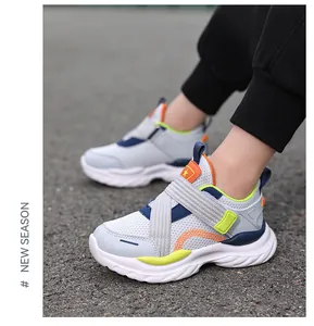 Vista lateral de zapatillas de malla transpirable para niños con detalles en naranja