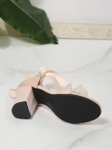 Detailed bottom view of pink suede block heel sandal with elegant ruffle trim design