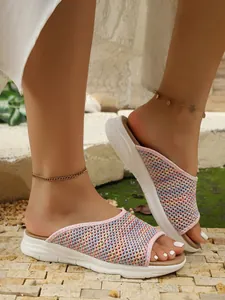 Vue rapprochée de sandales en maille rose multicolore respirantes portées à l'extérieur