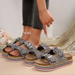 Detail view of sparkly silver platform sandals with double buckles and rainbow sole.