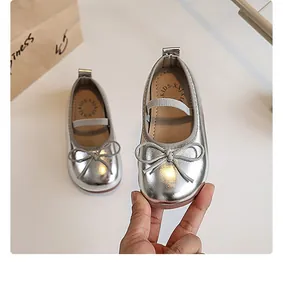 Close-up detailed view of silver girls' princess shoes with a bow and elastic strap