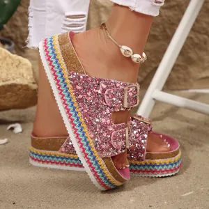 Close-up of pink glitter platform sandals with ethnic woven sole and double buckles