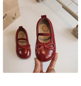 Close-up of a shiny red children's Mary Jane shoe with a delicate bow detail