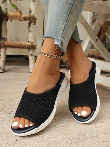 Gros plan de mules respirantes en maille noire pour femmes avec semelles plates blanches