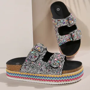 Close-up detail of ethnic platform sandals with colorful rhinestones and buckles