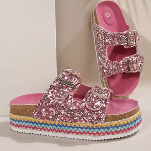 Detail view of pink glitter sandals with rainbow braided platform and double buckles