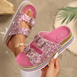Close-up view of pink glitter platform sandals featuring double buckles and colorful sole edge