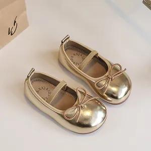 Elegant shiny gold Mary Jane shoes for girls featuring a bow and elastic strap closure