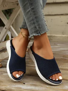 Gros plan sur des claquettes en mesh bleu marine respirant avec des semelles blanches