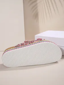 Detail view of ethnic style platform sandal with white ribbed sole and colorful braided trim