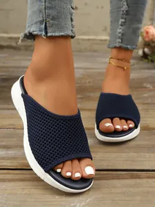 Gros plan de mules plates en mesh bleu marine à bout ouvert pour femmes.