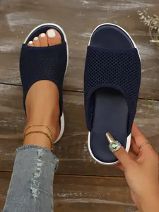 Zoom sur les pantoufles en maille respirante bleu marine avec semelles blanches plates