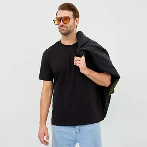 Detailweergave van een man die een los zwart ademend katoenen T-shirt met korte mouwen draagt