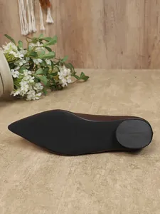 Gedetailleerde weergave van de antislip zwarte rubberen zool op bruine platte schoenen