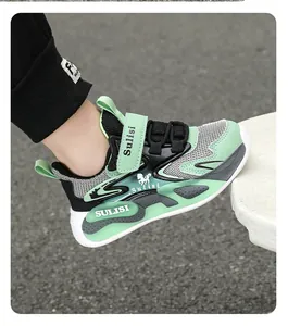 Detalle de la zapatilla deportiva de malla verde menta y negro para niños con tira de velcro