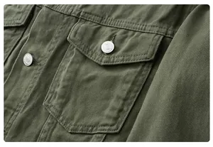 Close-up detail of olive green denim jacket pocket with engraved vintage metal buttons
