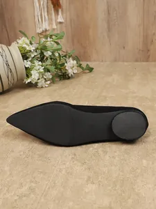 Gedetailleerd overzicht van de antislipzool van een klassieke zwarte puntige platte schoen