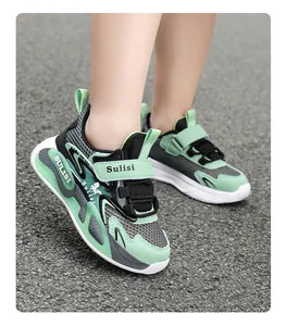 Detalle de zapatillas de malla transpirable verde para niños en superficie de asfalto.