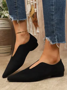 Detailopname van elegante zwarte suède puntige ballerina's met stijlvolle V-hals wreef