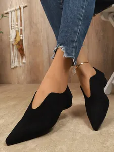 Gedetailleerde weergave van zwarte puntige ballerina's met V-hals en zachte suède-look