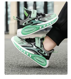 Vista de perfil lateral de zapatillas deportivas infantiles de malla transpirable verde y gris.
