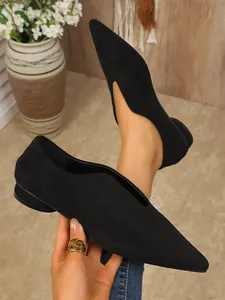 Detailopname van elegante zwarte suède ballerina's met puntige neus en V-hals voor dames.
