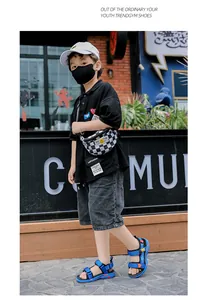 Boys' blue beach sandals with adjustable straps shown in a street style setting