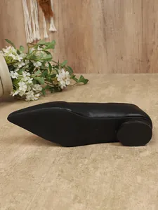 Gedetailleerd overzicht van de zool en ronde hak van deze zwarte platte schoenen met puntige neus