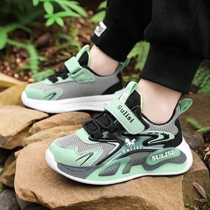 Zapatillas de malla transpirable para niños en verde y gris sobre rocas naturales