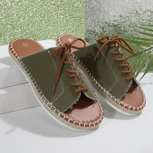Vue détaillée des mules en toile verte avec lacets marrons et surpiqûres