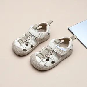 Sandales de sport pour enfants à bout fermé et brides velcro en coloris crème.