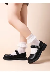 Detailansicht von schwarzen Mary-Jane-Schuhen für Mädchen mit weißen Spitzensocken