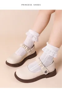 Detailansicht cremefarbener Mary-Jane-Lederschuhe für Mädchen mit Spitzensocken
