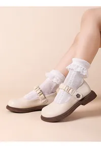 Detailansicht der beigen Mary Jane Mädchenschuhe mit Rüschen und Spitzensocken