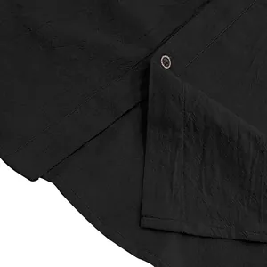 Nahaufnahme eines schwarzen Leinenhemdes mit Stofftextur und dekorativem Knopfdetail.