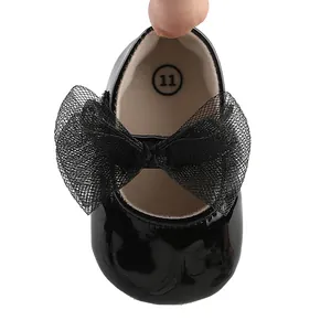 Primer plano de zapato de princesa para bebé en charol negro con lazo de malla
