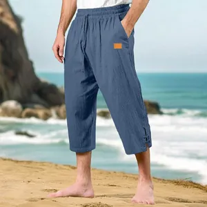 Detail view of blue cotton linen beach pants with drawstring waist and leather label