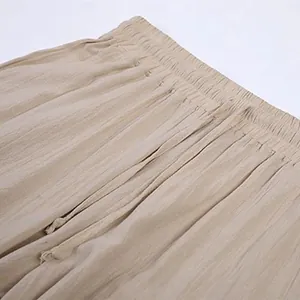 Detailed close-up of elastic waistband and drawstring on men's cotton linen trousers.