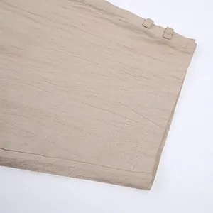 Close-up detail of breathable cotton linen fabric and hem stitching on men's casual pants.