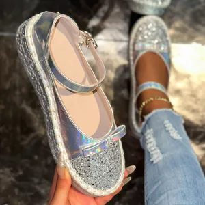 Close-up of silver holographic Mary Jane flats with glitter detail and bow accent