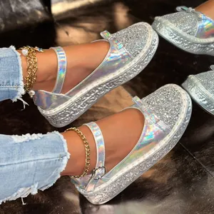 Close-up of silver glitter and holographic platform Mary Jane shoes worn with jeans