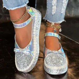 Close-up of silver holographic glitter Mary Jane platform shoes with stylish bow detail.