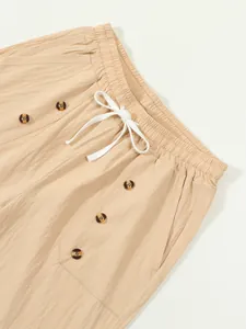 Close-up of men's beige cotton linen shorts featuring elastic waist and button detail