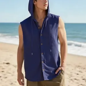 Camicia smanicata con cappuccio da uomo in lino blu scuro in una scena di spiaggia.