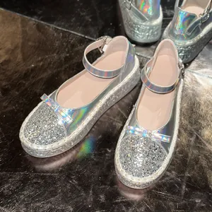 Close-up detail of silver glitter Mary Jane platform shoes with holographic straps