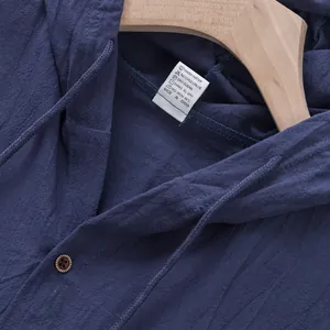 Dettaglio dell'etichetta di lavaggio di un gilet in lino blu con cappuccio da uomo