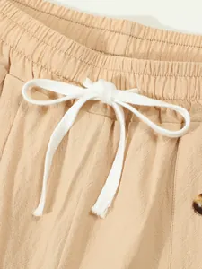 Close-up of cotton linen shorts featuring an elastic waistband and white drawstring bow.