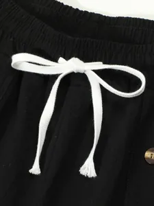 Detail of elastic waistband and white drawstring on black cotton linen casual shorts
